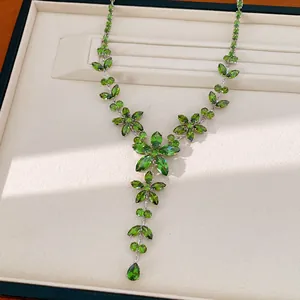 Macro view of exquisite necklace featuring emerald green zircon flowers and leaves
