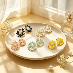 Détail montrant des boucles d'oreilles marguerites en émail coloré dans un décor champêtre