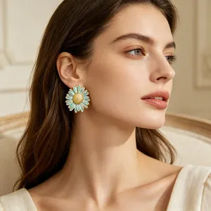 Gros plan d'élégantes boucles d'oreilles marguerites bleu pastel portées par un mannequin