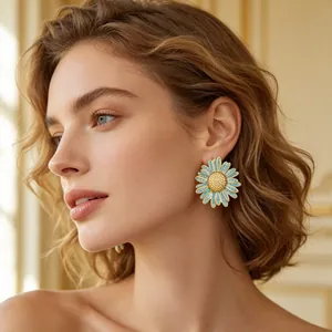 Gros plan d'une boucle d'oreille marguerite bleue portée par un modèle sous une lumière.