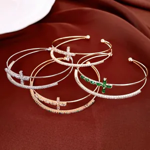 Vista di gruppo di bracciali a croce a doppio strato placcati in oro 18k con zirconi