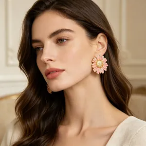 Mannequin élégant portant des boucles d'oreilles marguerite en émail rose et or.