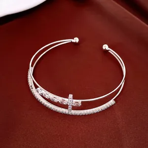 Vista dettagliata dell'elegante bracciale rigido a doppio strato con croce di zirconi