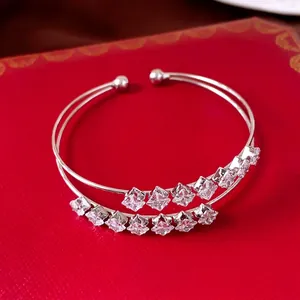 Double-layered silver-toned bangle with clear square-cut zirconia on red backdrop