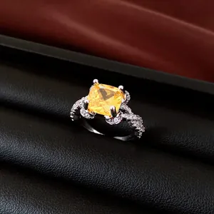 Exquisite silver-toned ring featuring a square yellow gemstone and pavé twisted band design.