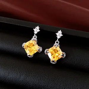Elegant silver needle earrings featuring cushion-cut yellow zircon stones.