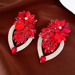 Detailweergave van grote rode kristallen bloemenoorbellen met fonkelende strass.