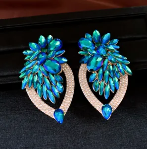 Gedetailleerd overzicht van oversized groenblauwe kristallen bloemoorbellen met strass.