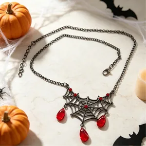 Detailopname Halloween spinnenweb ketting met rode druppelvormige stenen en gunmetal afwerking