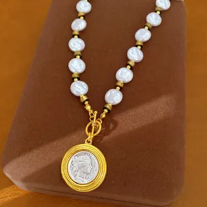 Close-up of French retro necklace featuring wrinkled pearls and a gold coin portrait pendant