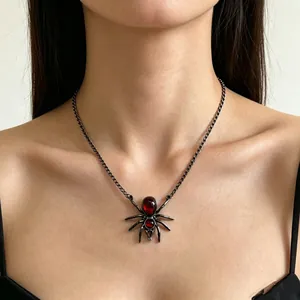 Detailweergave van donkere spin ketting met rode traan edelstenen op nek