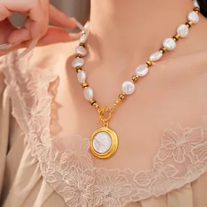 Close-up view of a vintage French style pearl necklace with an engraved portrait pendant.