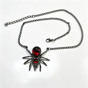 Macro detailweergave van donkere spinnenketting met levendige rode druppel edelstenen