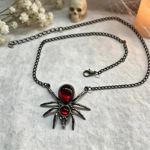 Detailweergave van gotische spinnenketting met rode druppelstenen voor Halloweenfeest