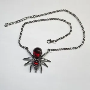 Gedetailleerd overzicht van een gotische spinnenketting met rode druppelstenen en ketting