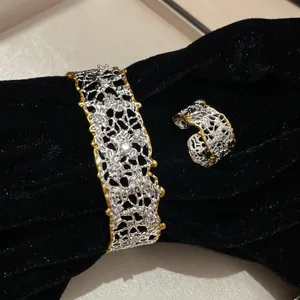 Vista dettagliata del set bracciale e anello vintage bicolore argento e oro traforato.