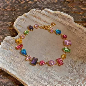Gros plan d'un bracelet en or de style dopamine avec des zircons colorés de formes variées.