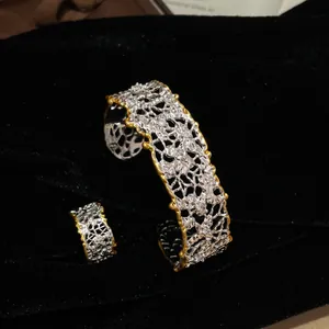 Dettaglio di un set di bracciale e anello vintage traforati con design a pieghe