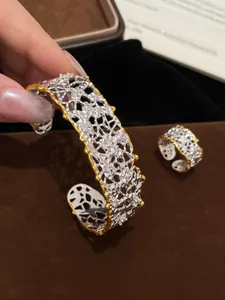 Dettaglio di un bracciale a polsino vintage traforato con bordi dorati e pietre