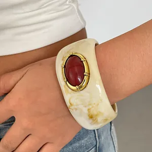 Detailweergave van vintage gemarmerde hars armband met een grote rode ovale steen inleg.