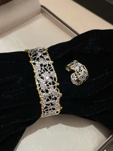Vista dettagliata del set di gioielli vintage argento e oro su elegante velluto nero
