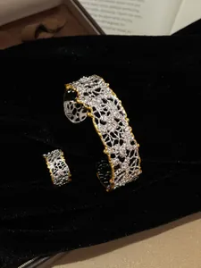 Primo piano di set bracciale e anello traforati plissettati vintage oro e argento
