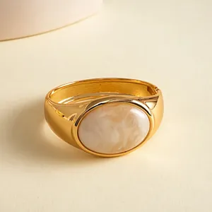 Gedetailleerde macro-opname van gouden armband met een gemarmerde ovale harssteen