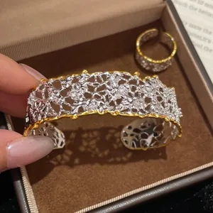 Vista dettagliata di un bracciale rigido vintage bicolore traforato con zirconi lucidi.