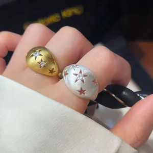 Detailweergave van geborstelde metalen ringen met sterren en zirkonia stenen.