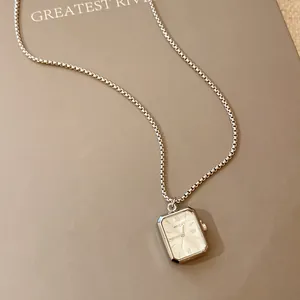 Vue détaillée d'un collier pendentif montre rectangulaire minimaliste avec chaîne