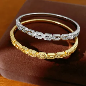 Gedetailleerde opname van luxe 18K vergulde zirkonia armbanden met een overlappend C-ontwerp