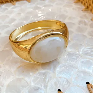 Vintage chunky gold-tone bangle featuring a large oval marbled white resin insert