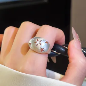 Elegante geborstelde zilveren ring met sterpatronen en een fonkelende zirkoon in het midden