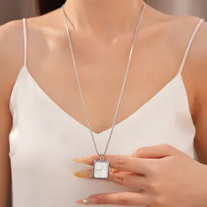 Modèle portant un collier pendentif montre rectangulaire en argent de luxe sur chaîne