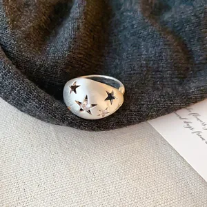 Detail van een geborstelde zilveren ring met stervormige uitsnijdingen en een zirkoon.