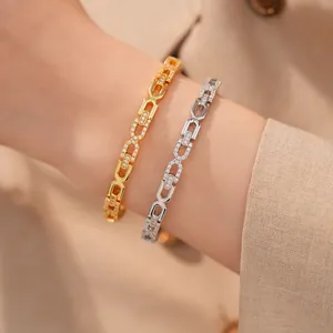 Close-up van 18K goud en zilver vergulde armbanden met fonkelende zirconia-schakels.