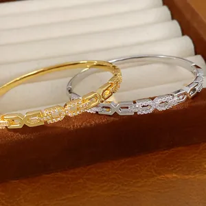 Detaillierte weergave van 18K vergulde armbanden met fonkelende geometrische schakels