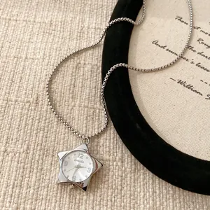 Vue détaillée d'un collier montre de poche en forme d'étoile argentée avec chaîne maille.