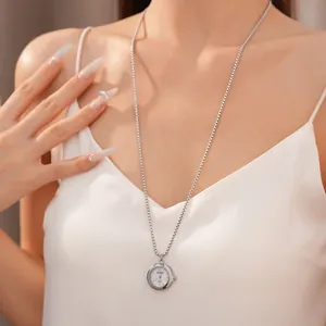 Élégant collier pendentif montre à gousset argentée portée par mannequin sur chaîne