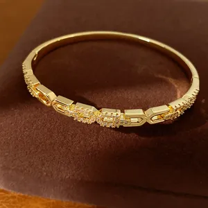 Close-up van een elegante 18K vergulde armband met glinsterende pavé-schakels van zirkoon.