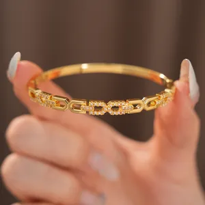 Close-up van 18K vergulde bangle met sprankelende zirkonia geometrische schakels