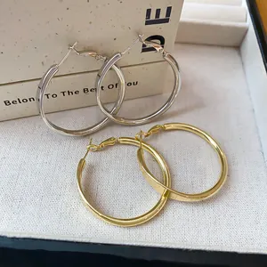 Hochwertige Detailansicht großer minimalistischer Creolen in Gold- und Silberausführung
