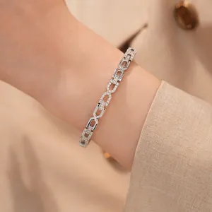 Detailopname van een zilverkleurige armband met zirkonia en dubbele C-schakels