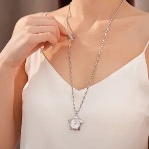 Détail d'un collier montre de poche en forme d'étoile porté sur un caraco en soie