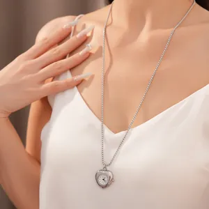 Gros plan d'un collier montre de poche en forme de cœur porté par un mannequin