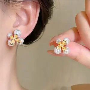 Elegante bloemen oorbellen in Franse stijl met witte parels en gouden details.