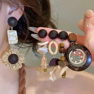 Detailed view of vintage wooden and shell drop earrings in a bohemian resort style