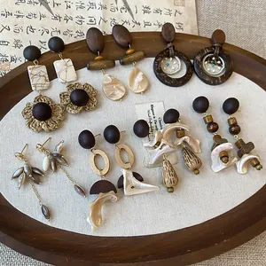Collection of handcrafted vintage wood and shell drop earrings in a bohemian resort style.