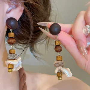 Detailed view of vintage wood and shell drop earrings showing natural textures and luster.