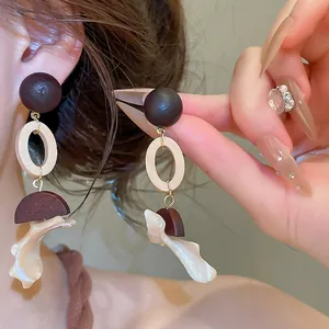 Detailed view of retro wood and shell pendant earrings in New Chinese style